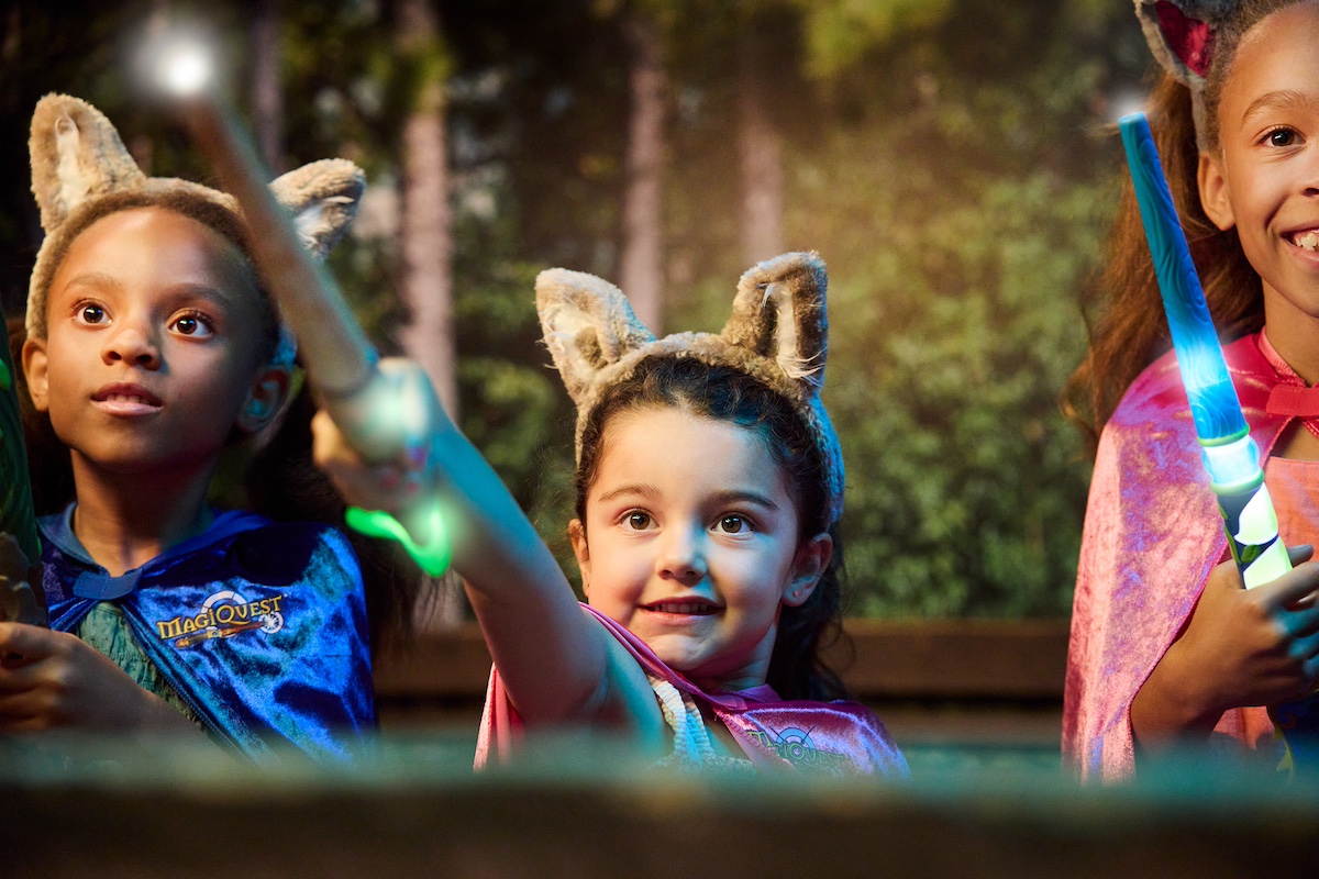 Kids playing MagiQuest with glowing wands and wolf ears at Great Wolf Lodge Traverse City.