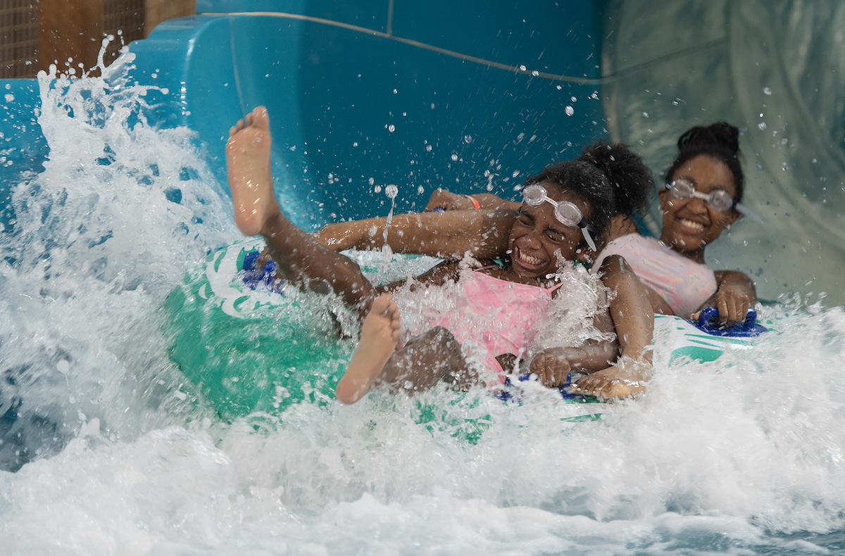 Two girls laughing and riding a water slide at Great Wolf Lodge in Traverse City, Michigan.