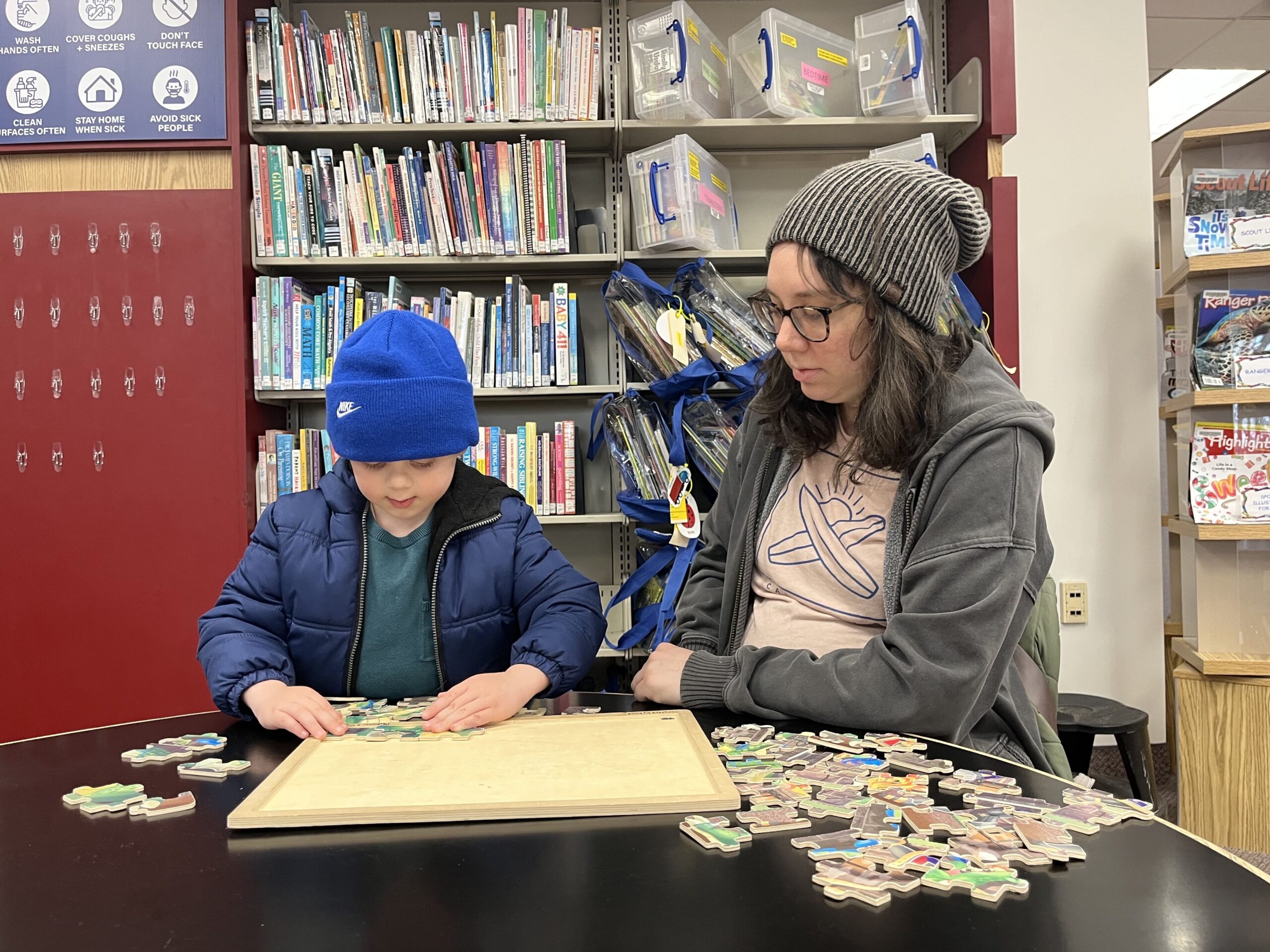 Local mom Kelly Falcheck of Livonia and her son Elliott, 4, explore puzzles at Livonia Public Library children's section.