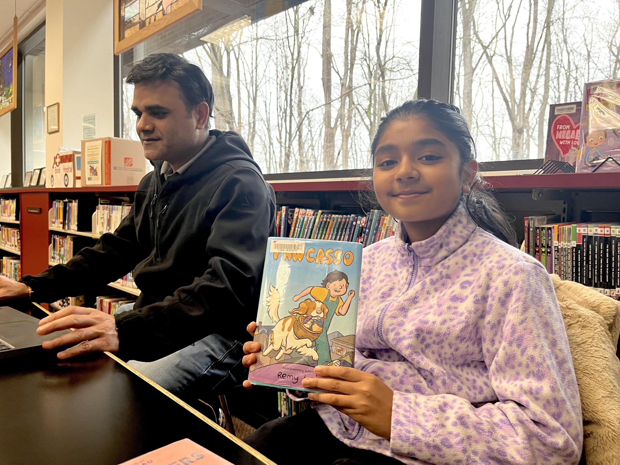 Naresh Oza of Troy and daughter Anvi, 10, work and read at the Livonia Public Library.