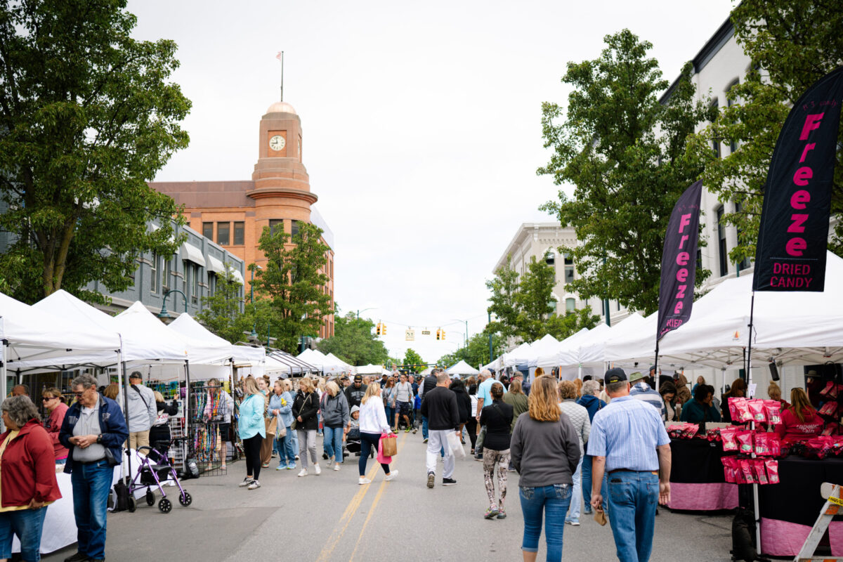 Families enjoying the Crooked Tree Art Fair in downtown Traverse City, a fun summer event featuring local vendors, art, and activities perfect for all ages.