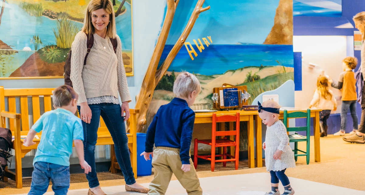 Young children play and explore with their caregiver at the Great Lakes Children's Museum in Traverse City — an interactive and educational indoor activity perfect for families with young kids.