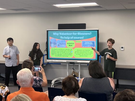 Academy Explorer 6 students present on volunteering at Gleaners, explaining how student-led efforts support hunger relief through food distribution and community service.