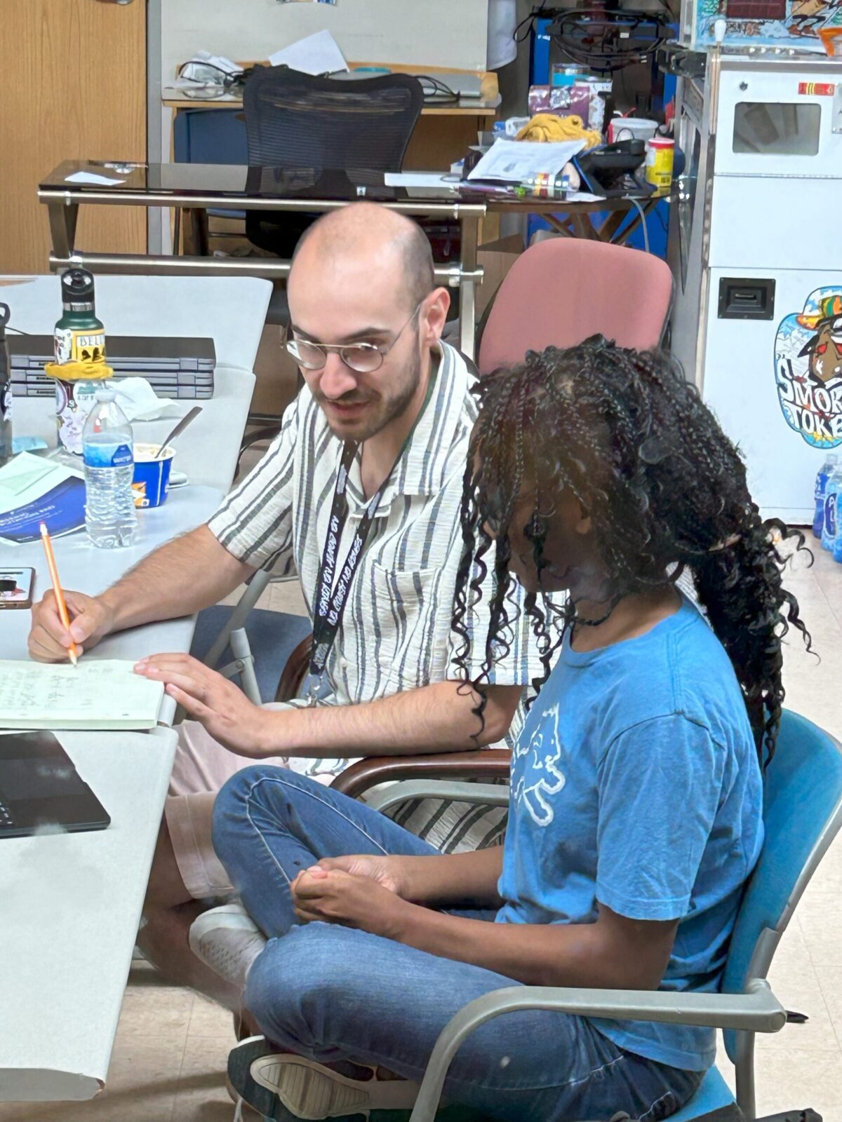 Teacher providing one-on-one academic support to a student at Aim High School, showcasing personalized special education accommodations in a supportive classroom setting.
