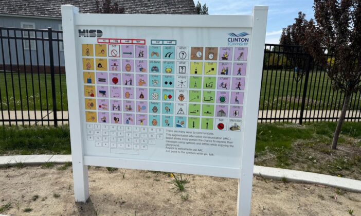 Augmentative communication board at Clinton Township inclusive playground, providing visual symbols and letters to support nonverbal and speech-delayed children in expressing themselves.