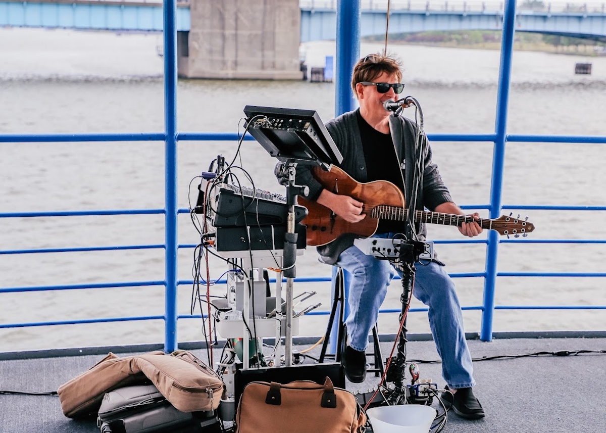 Musician performing live along the Bay City riverfront, a popular stop for Michigan summer vacation day trip destinations