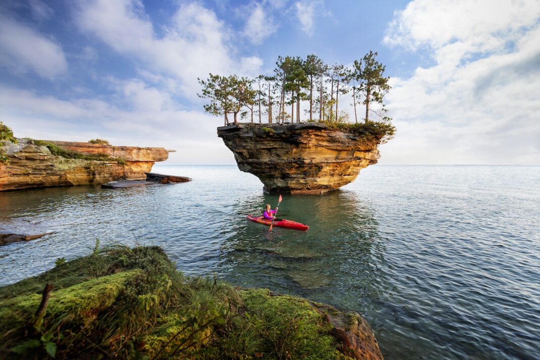 Kayaker exploring Turnip Rock in Port Austin, one of the most scenic Michigan summer vacation day trip destinations on Lake Huron