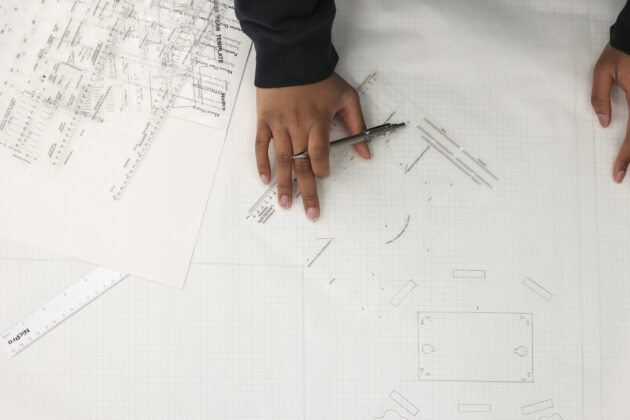 Detroit Achievement Academy student using templates and graph paper to draw a site plan for the student-designed park project