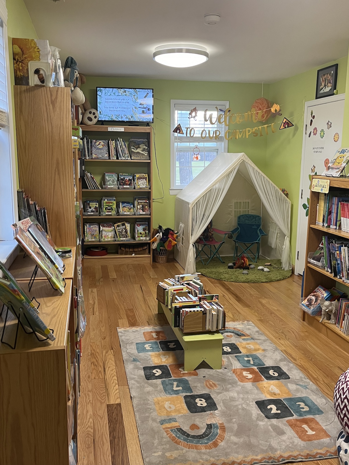 Indoor campsite-themed play corner with chairs and pretend campfire at Ray Township Public Library — one of the best libraries in Macomb County for imaginative and cozy early literacy spaces.