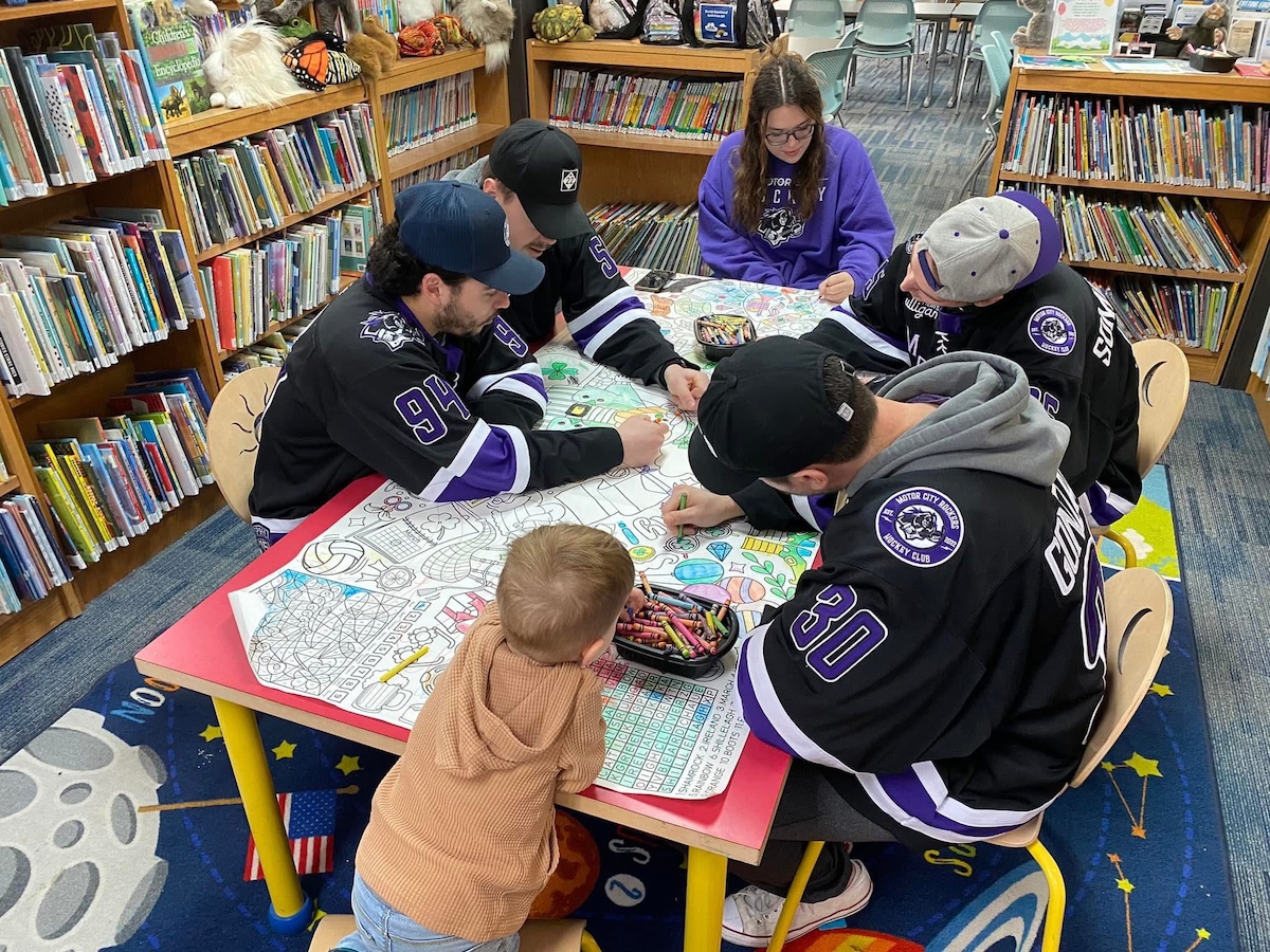 Harrison Township Public Library hosts a storytime and coloring activity with local hockey players, showcasing why it's one of the best libraries in Macomb County for engaging youth programs.