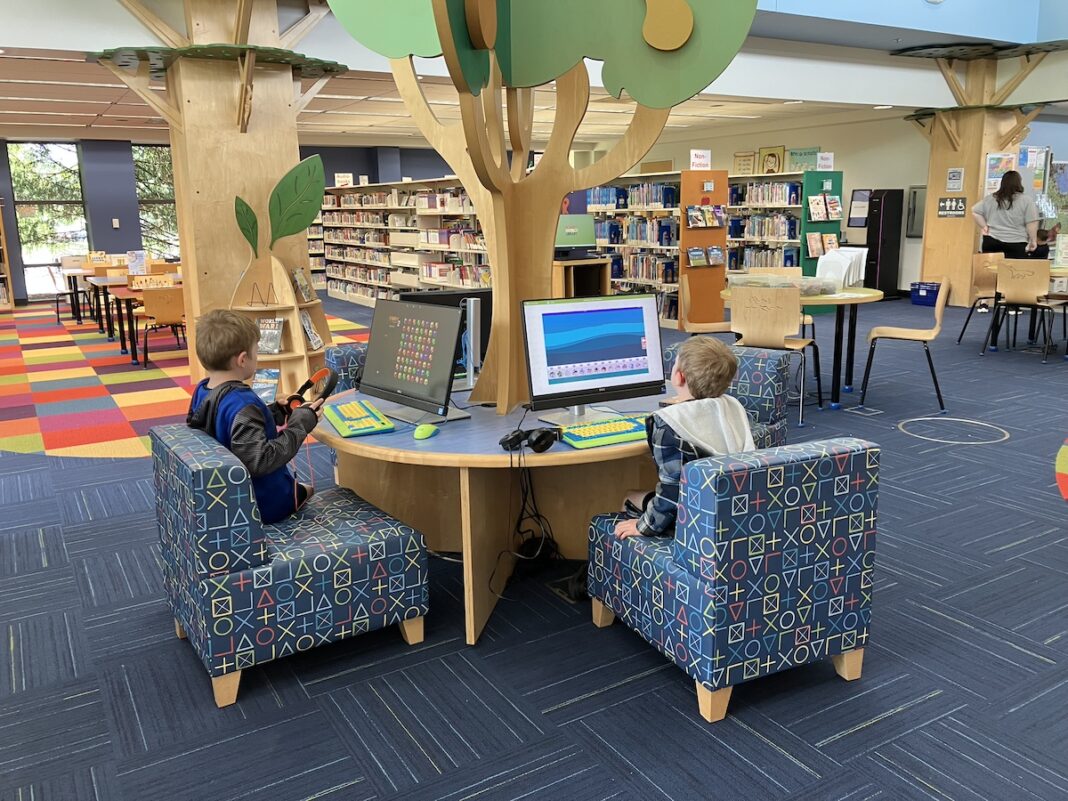 Children using educational games on computers in the vibrant kids’ tech area at Romeo Graubner Library — one of the best libraries in Macomb County for family-friendly technology and learning.