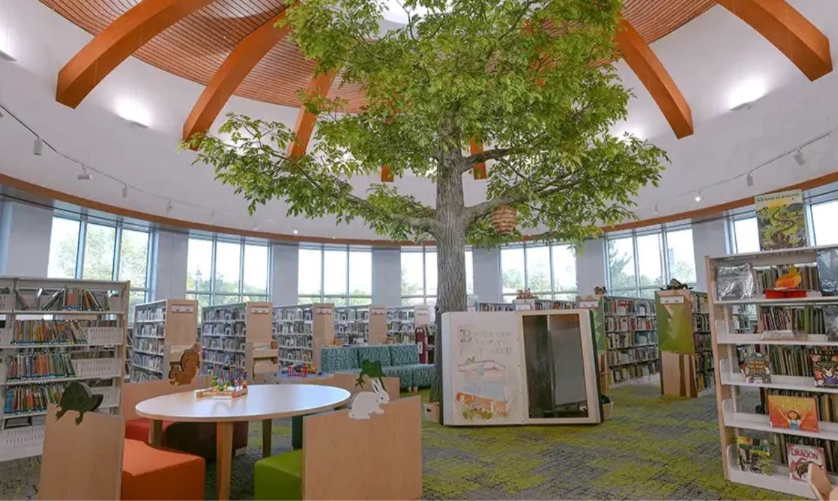 Shelby Township Library children's area with whimsical tree centerpiece and book displays, showcasing one of the best libraries in Macomb County for families.
