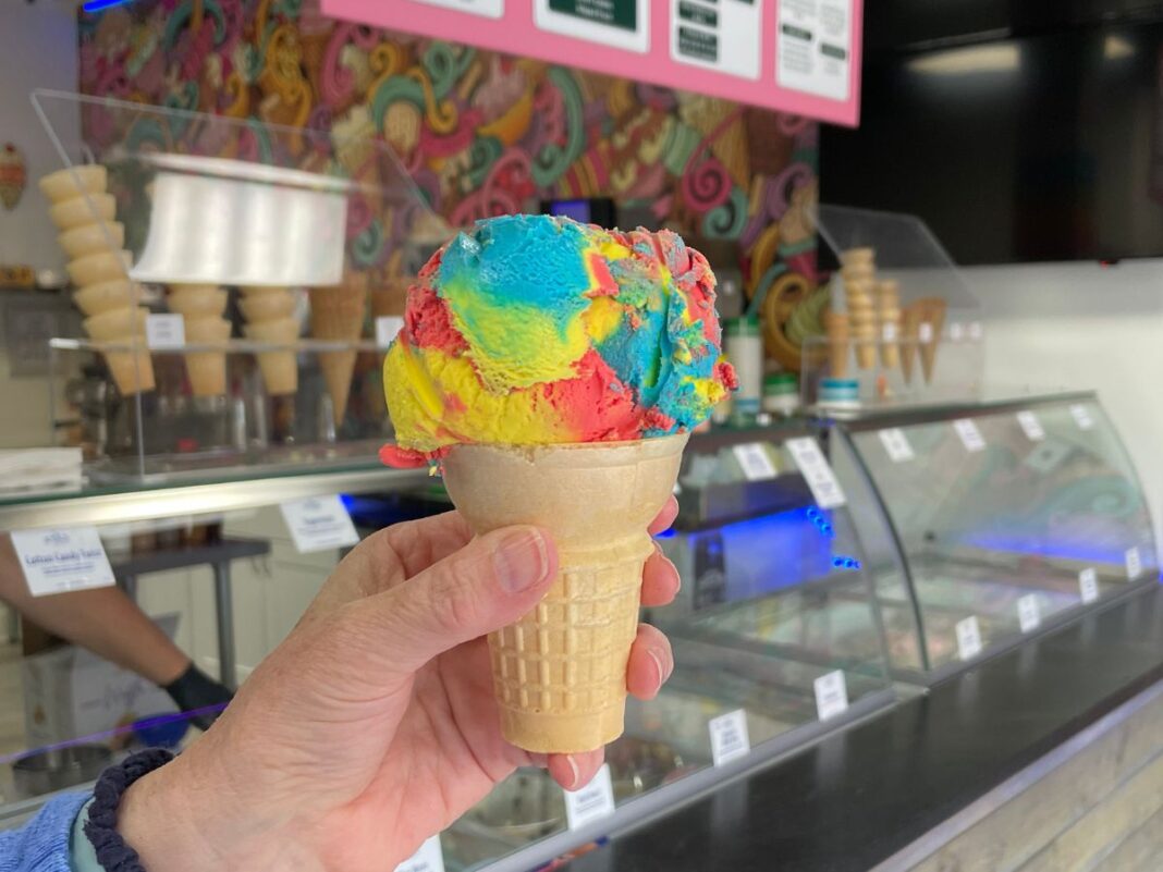 Close-up of a colorful Superman ice cream cone at a Michigan ice cream shop, featuring red, yellow and blue swirls