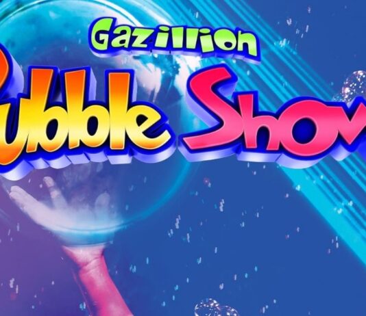 Gazillion Bubble Show Gazillion Bubble Show at Whiting Auditorium on May 2, featuring a performer holding a giant bubble surrounded by smaller bubbles and colorful lights.