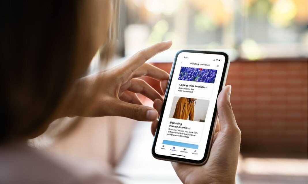 Parent holding smartphone, representing access to online mental health support for busy parents through the Teladoc Health app from Oakland Community Health Network