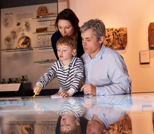 Free First Friday at Cranbrook Institute of Science Family with young child explores interactive exhibit at the Michigan Science Center during the Leonardo da Vinci Machines in Motion show
