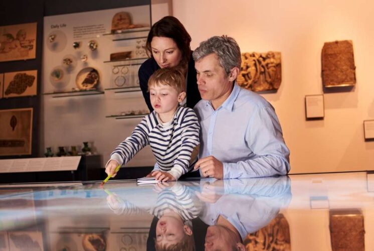 Family with young child explores interactive exhibit at the Michigan Science Center during the Leonardo da Vinci Machines in Motion show