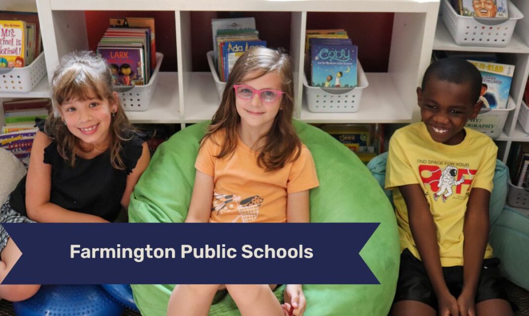 Farmington Public Schools students sit in a reading corner, smiling together and surrounded by books that encourage a love of learning.