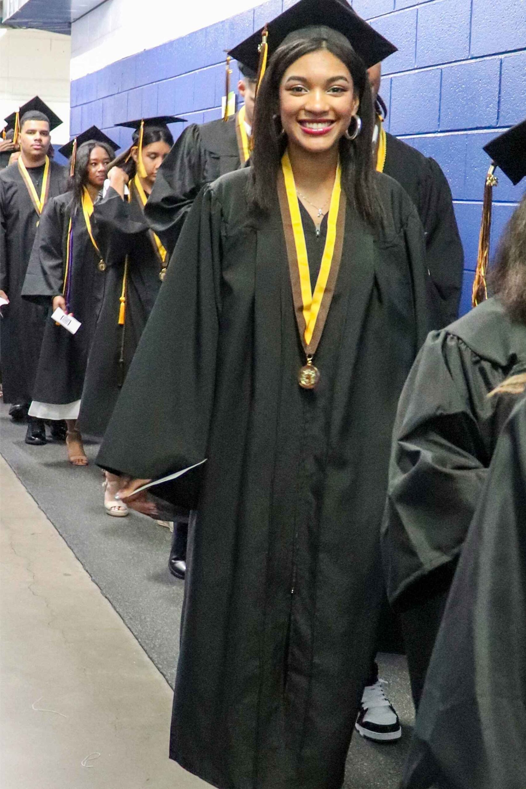 Farmington Public Schools students in caps and gowns walk in line during the North Farmington High School graduation ceremony.