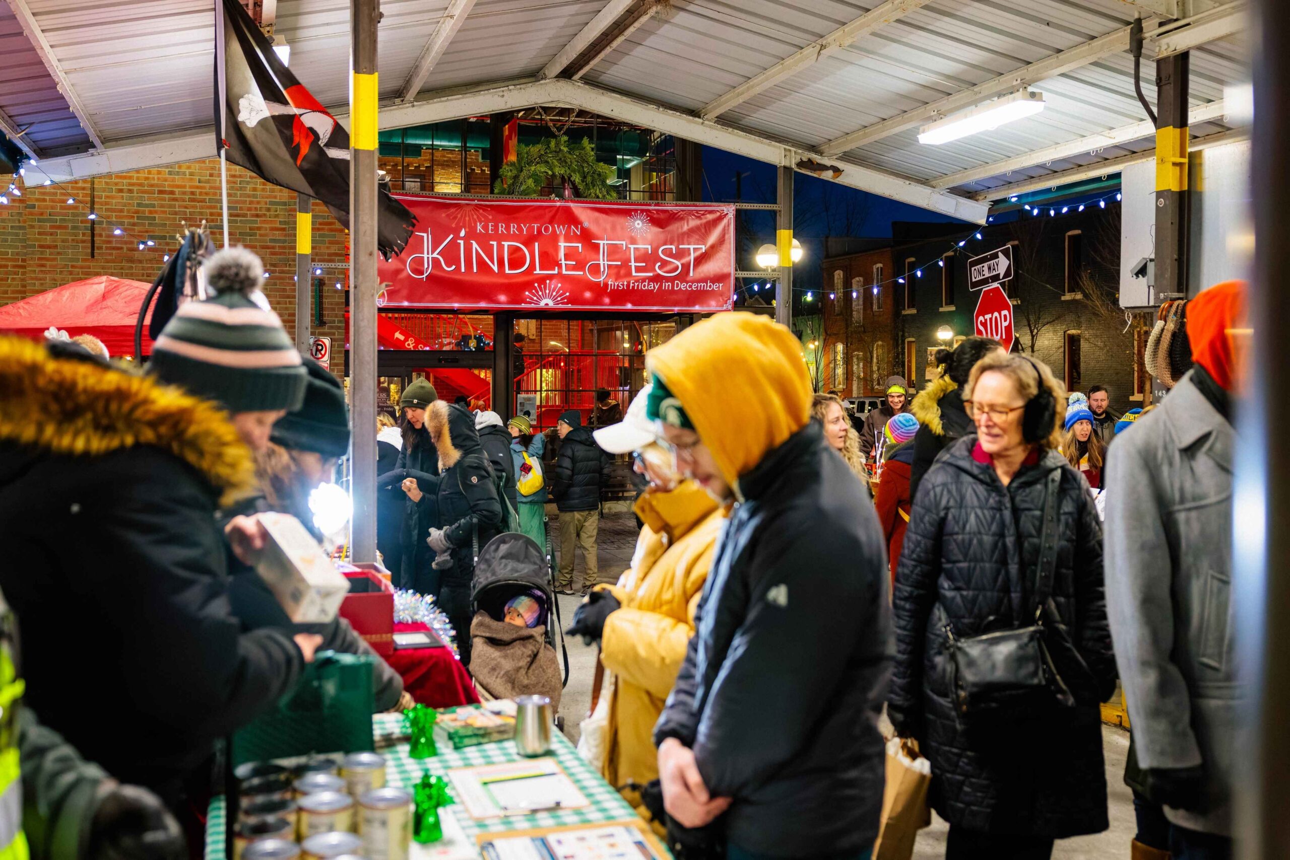 Families browse vendor booths and holiday lights at Kerrytown District KindleFest at Ann Arbor Farmers Market in Michigan.