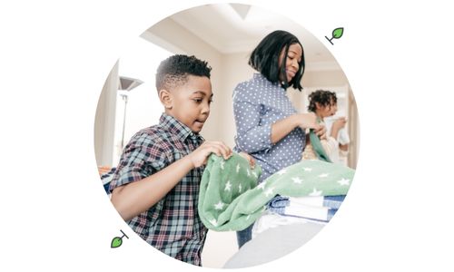 Parent and children folding laundry together at home to build communication and life skills for a child with autism.
