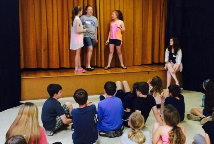 Kids perform acting and improv games on stage during the Acting and Improv Workshop in Troy, building confidence and teamwork.