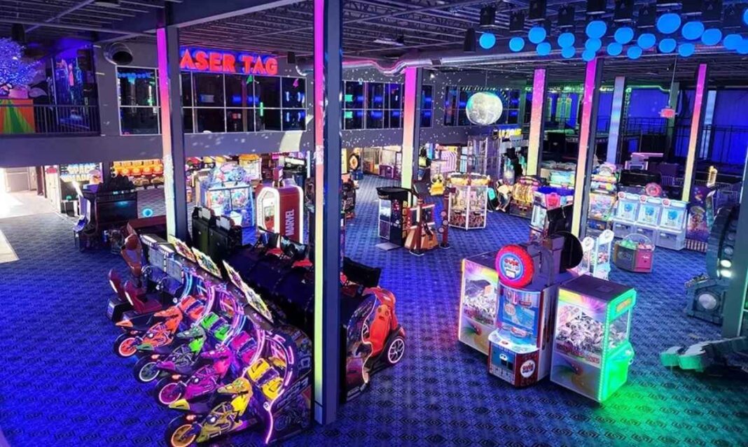 Colorful arcade floor at BIG Best in Games in metro Detroit with racing games, laser tag, and bright neon lights.