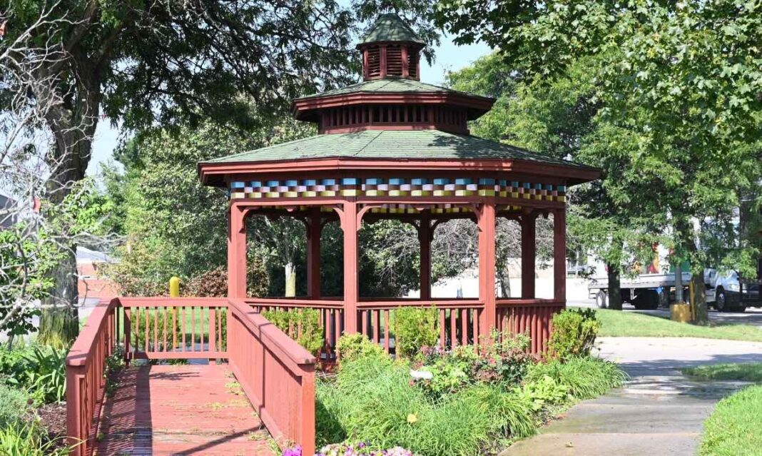 Gazebo surrounded by flowers and greenery at Center Line Beautification Park in Macomb County, Michigan, on a sunny afternoon.