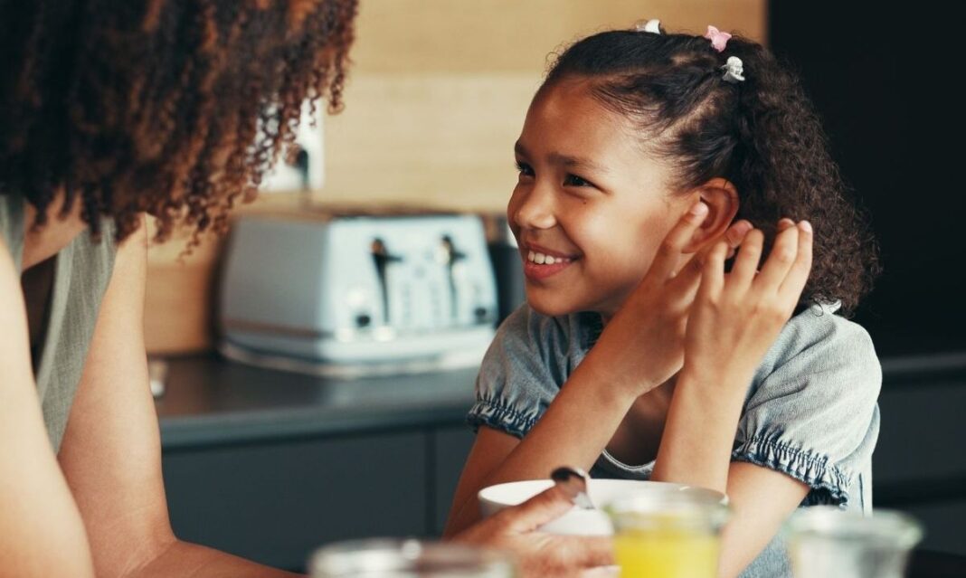 A Detroit parent talks with their young daughter at the kitchen table about making healthy choices and avoiding vaping, inspired by DWIHN prevention guidance.