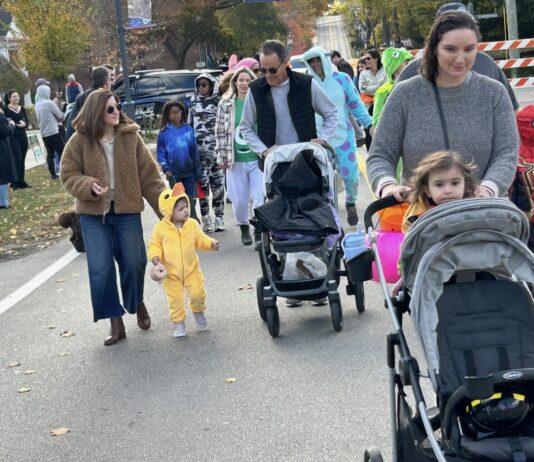 Families and kids in costumes take part in the Franklinstein Frenzy Halloween parade in downtown Franklin with strollers and trick-or-treat bags.