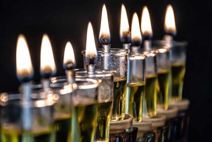 Close-up of a hanukkah menorah with all lights burning bright against a dark background celebrating the festival of lights event.