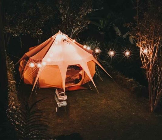 A glowing tent surrounded by string lights at night during the Hike the Lights Bonfire Night event at Muskegon Luge Adventure Sports Park.