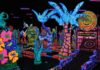 Glow-in-the-dark mini golf course at Putting Edge in southeast Michigan with neon palm trees, murals, and bright family fun decor.