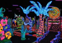 Glow-in-the-dark mini golf course at Putting Edge in southeast Michigan with neon palm trees, murals, and bright family fun decor.
