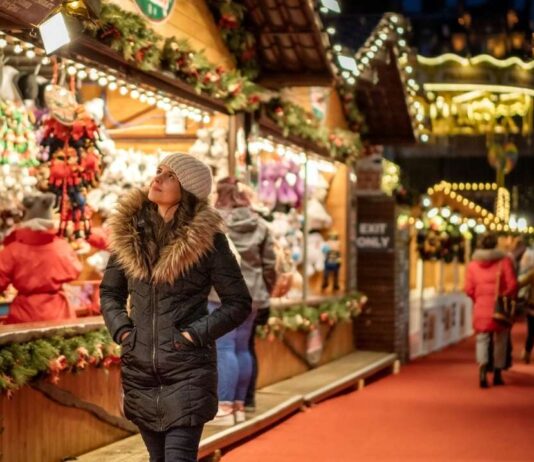Visitors stroll through the festive Downtown Rochester Lagniappe event with holiday lights, local shops, and Christmas market displays.