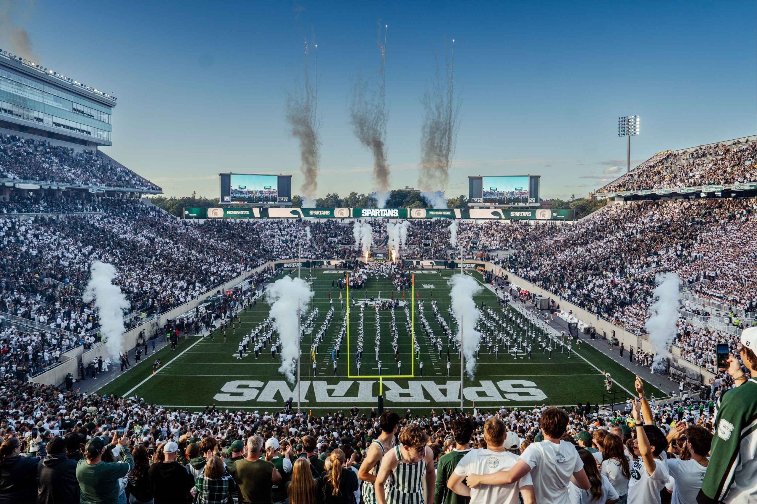 Michigan State University football fans cheer as fireworks launch over Spartan Stadium during a home game in East Lansing.