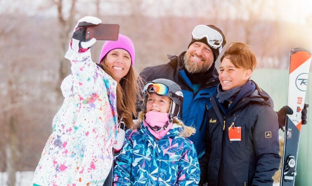 Family taking a selfie during their ski getaway at Treetops Resort in Gaylord, part of the Southeast Michigan Ford Dealers sweepstakes giveaway