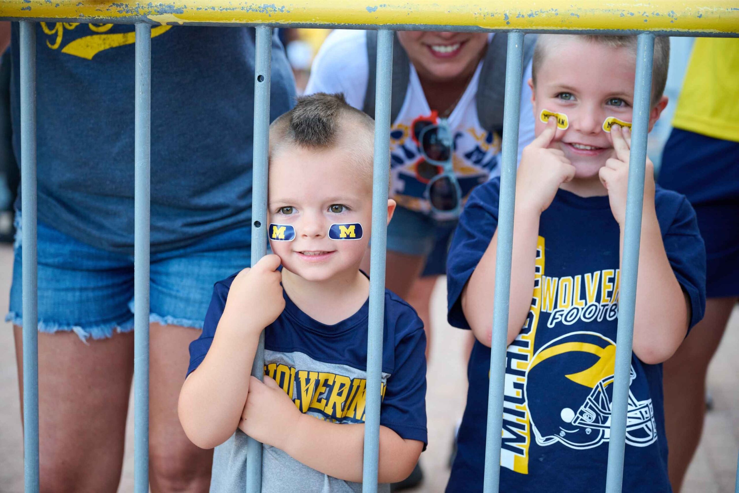 Young Michigan Wolverines fans show team spirit with face stickers and smiles before the University of Michigan vs. Fresno State football game.