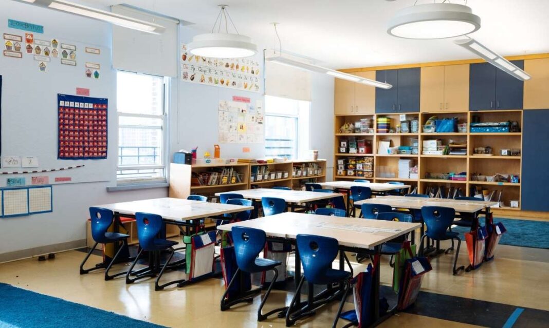 Empty elementary classroom with blue chairs and desks in Utica Community Schools as the district considers a new K–5, 6–8, 9–12 grade model.