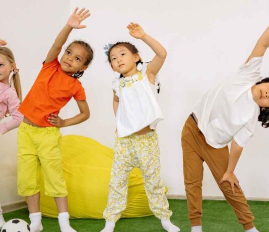 Vortex Gymnastics Spooktacular Trick or Tumble Open Gym Kids stretch and exercise together at Vortex Gymnastics Halloween open gym event for tumbling and fun in Wixom for ages 2