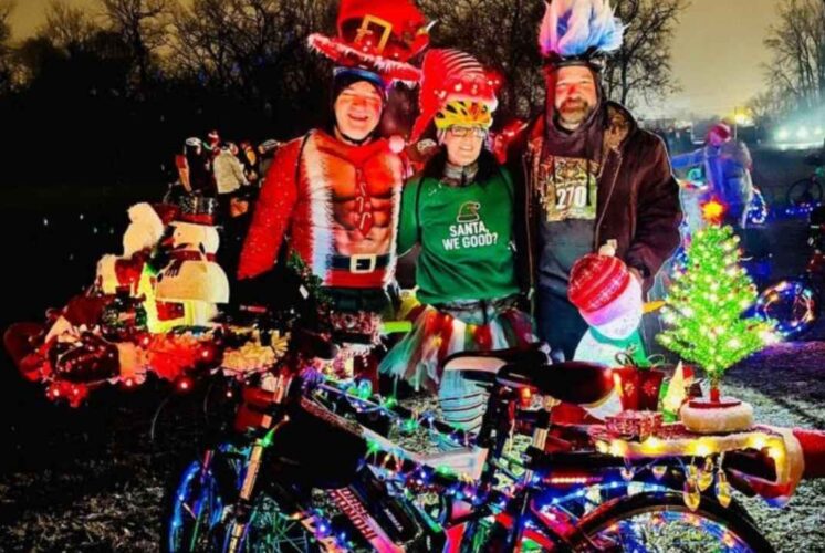 Participants dressed in festive holiday gear with decorated bikes at the 2025 Lightfest at Merriman Hollow Park in Westland.