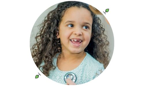 Young girl smiling while a medical professional checks her heart rate, illustrating autism primary care at Henry Ford Health