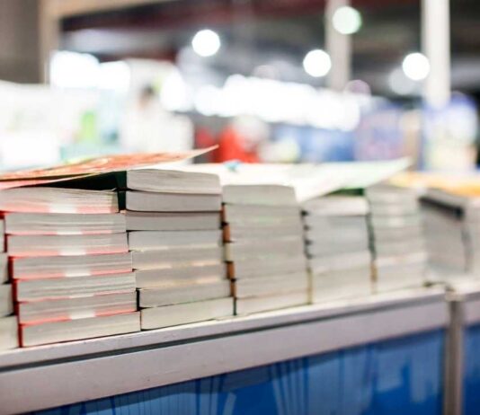 Stacks of books on display at the Brighter Day Community Book Fair in Ypsilanti where families enjoy free books and activities.