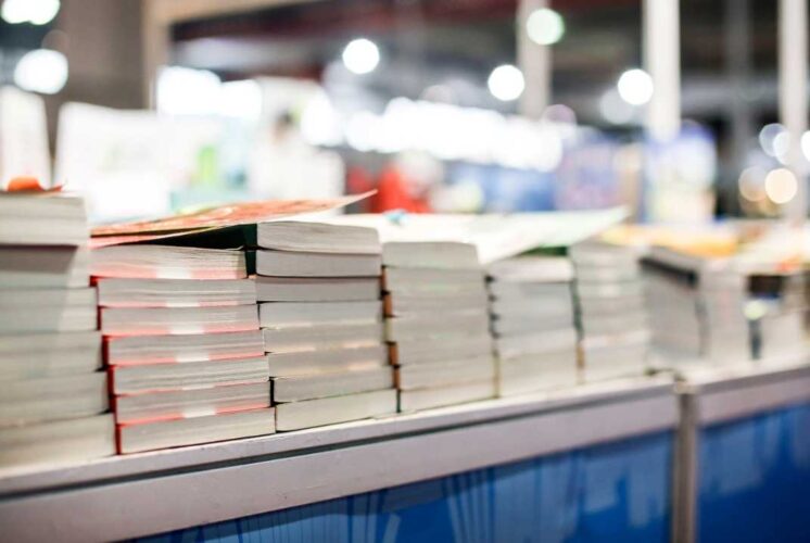 Stacks of books on display at the Brighter Day Community Book Fair in Ypsilanti where families enjoy free books and activities.