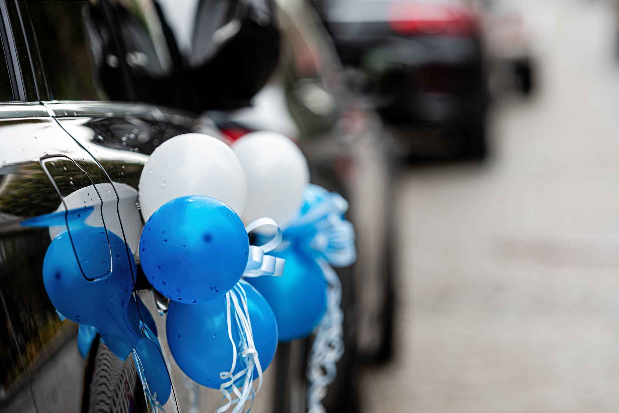 Blue and white balloons decorate a car door, showing Detroit Lions team spirit with fun blue and silver family SUV decorations.