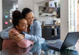 A parent and student smile while attending a virtual Early College Alliance Shadow Day at EMU to learn about high school and college opportunities.