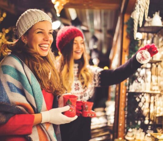 Grateful Gathering Holiday Market at Russell Industrial Center Two women shop for ornaments at a festive holiday market, capturing the spirit of the Grateful Gathering Holiday Market at Russell Industrial Center