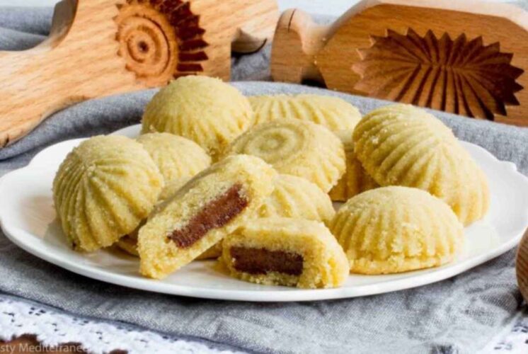 Plate of ma’amoul date cookies with wooden molds displayed for the Make a Date Cookie event at Huntington Woods Public Library.
