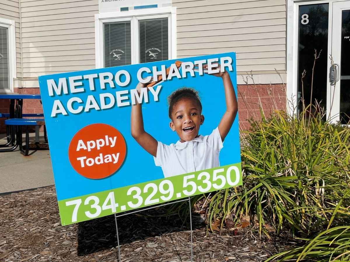 Metro Charter Academy enrollment sign outside the school building in Romulus, Michigan, encouraging families to apply today.