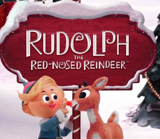 Rudolph the Red-Nosed Reindeer and Hermey the Elf stand by a snowy sign promoting the family holiday show at Trenton Village Theatre.